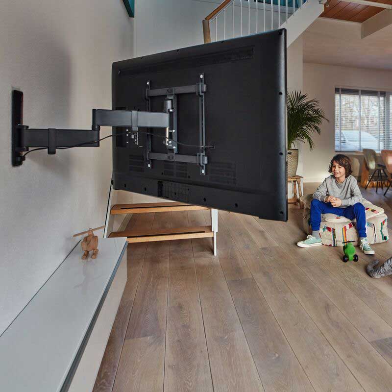 Full-motion TV wall mount bracket in a family living room